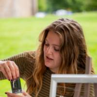 Student working a table of selling jewelry during Student Small Business Market.